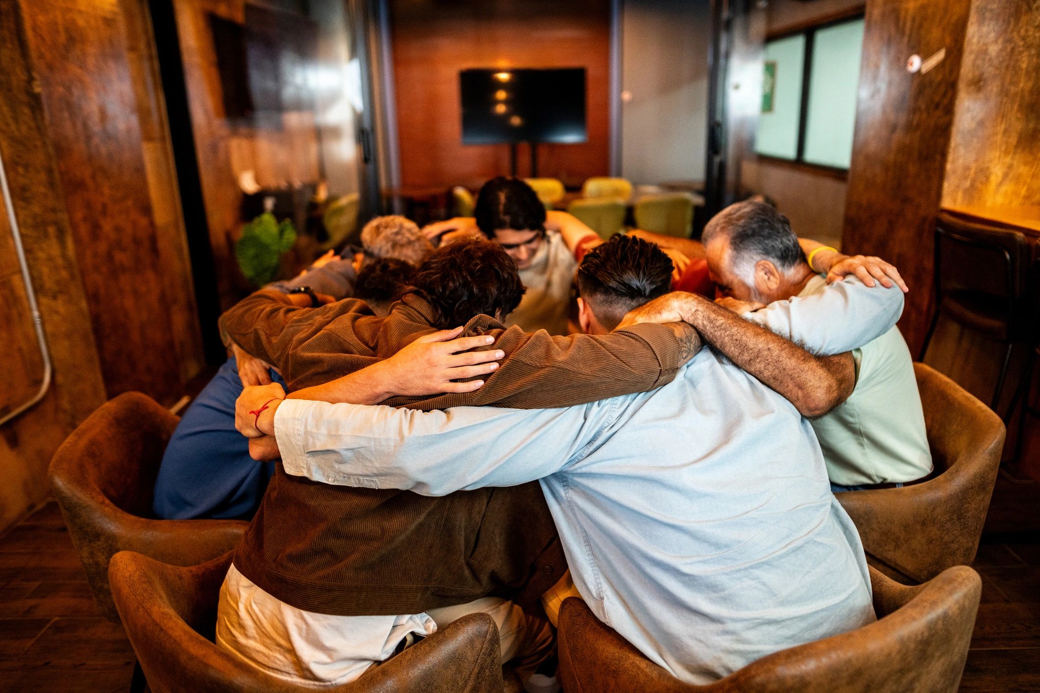 Men talking and supporting one another in a group