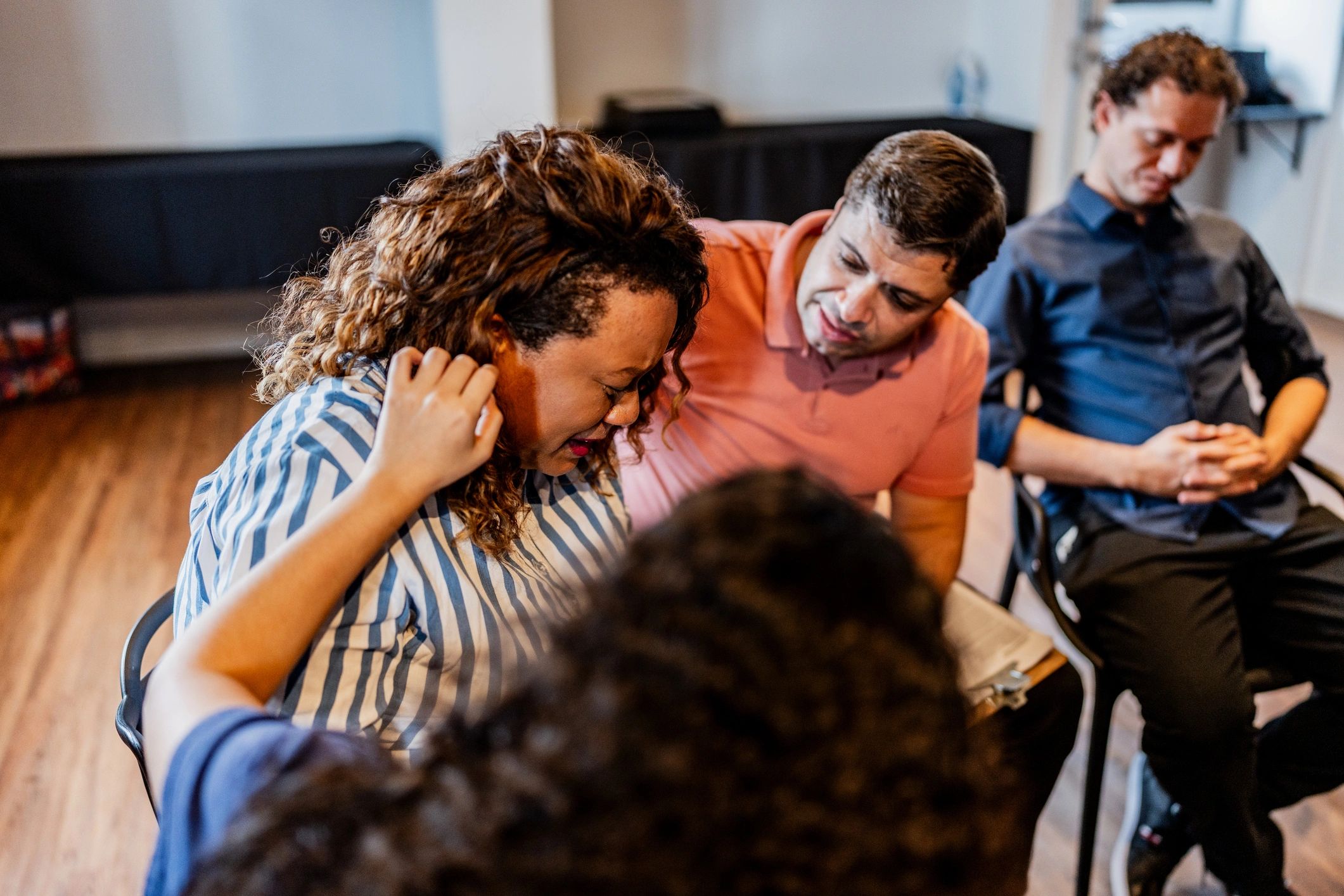 Woman receiving prayer and support in a group setting